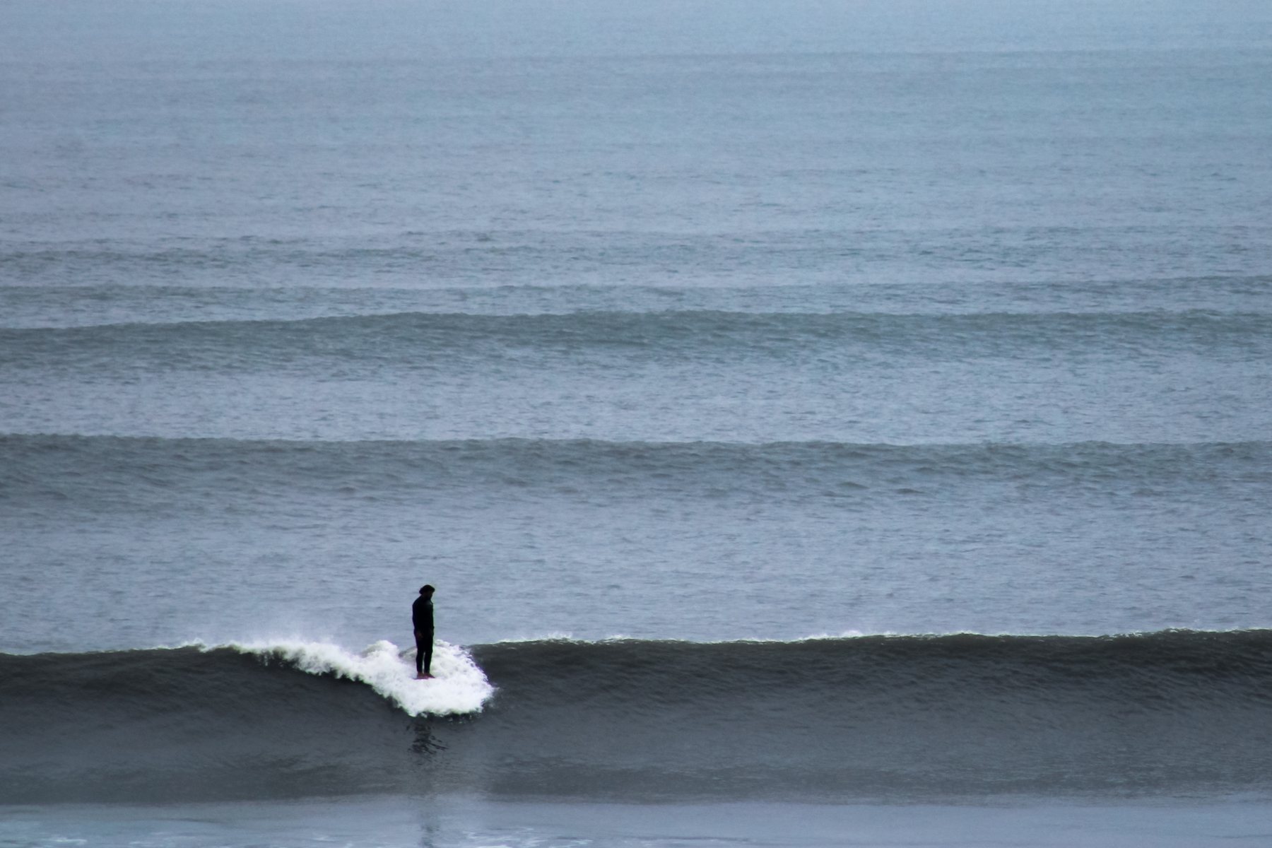 A longboard surfer riding a wave at Chicama, Peru