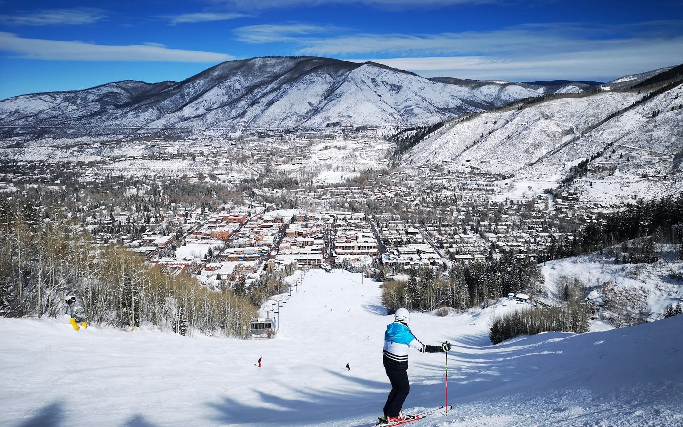 Skier on a snowy piste above Aspen, Colorado