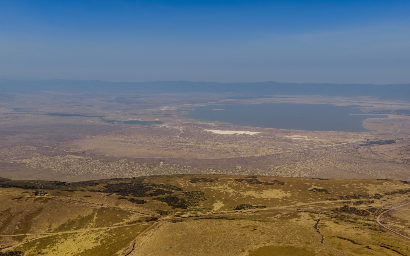Aerial view of the Ngorongoro Crater ecosystem in Tanzania with plains, highlands and a soda lake