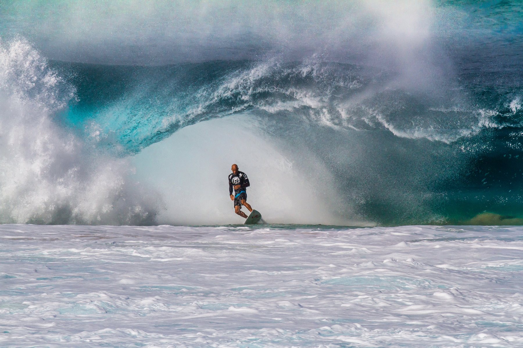 Surfer Kelly Slater riding a heavy barrelling wave at Banzai Pipeline on Oahu's North Shore
