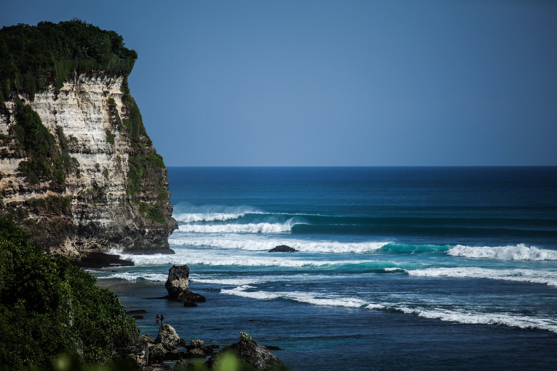 A wave barrelling off the point below the cliffs at Uluwatu, Bali