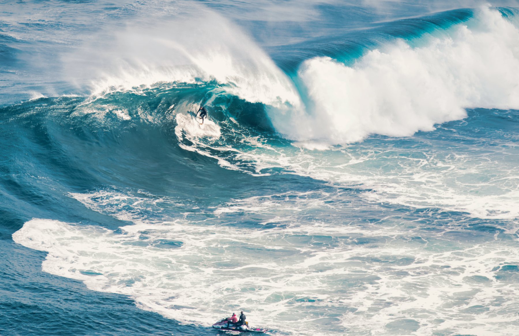 A surfer riding a wave off the rock ledge at Shipstern Bluff, Tasmania