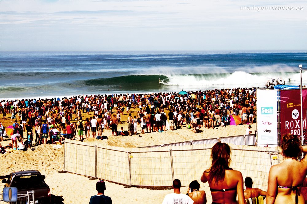 A barrelling wave at La Gravière in Hossegor watched by a crowd on the beach