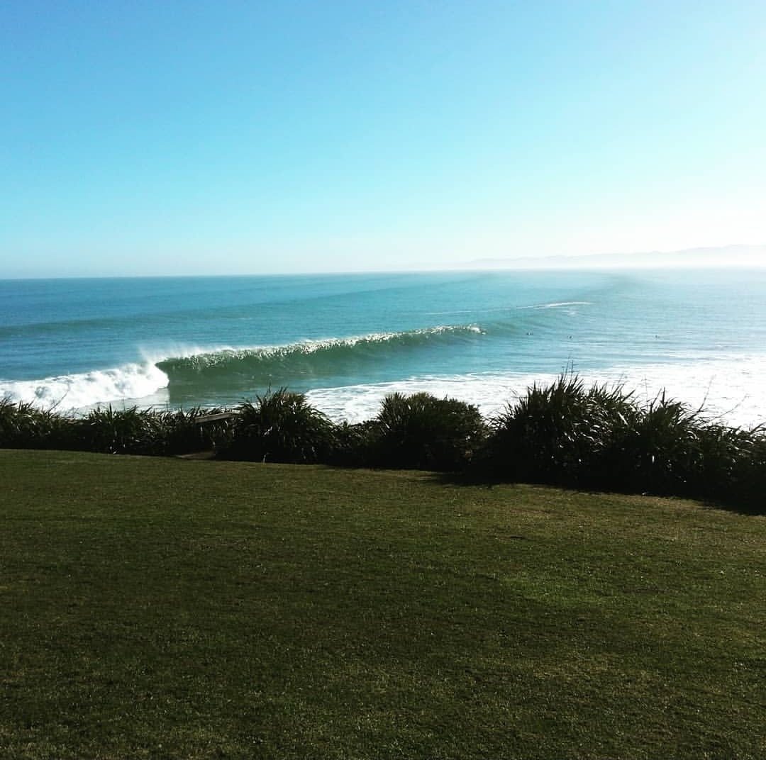 A long left-hand wave breaking at Manu Bay in Raglan, New Zealand